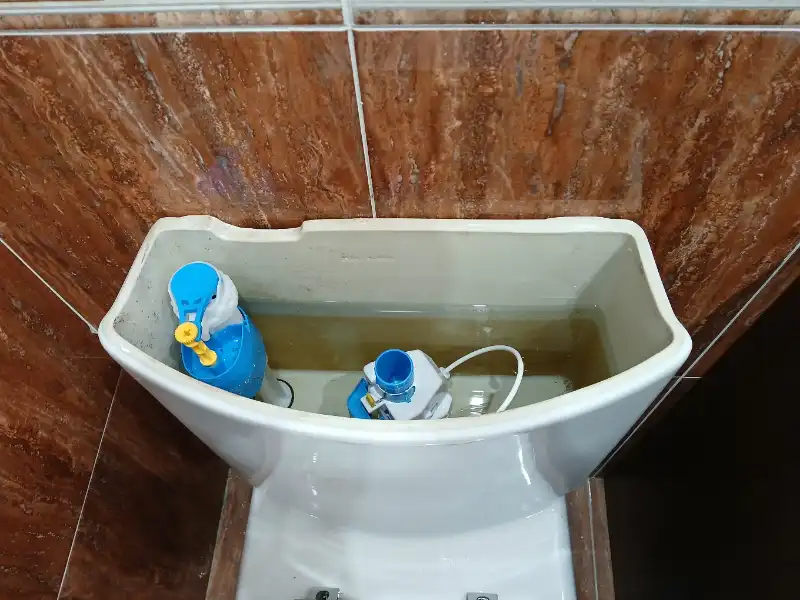 Fontanero Bilbao en Indautxu reparando el mecanismo interior de una cisterna de WC