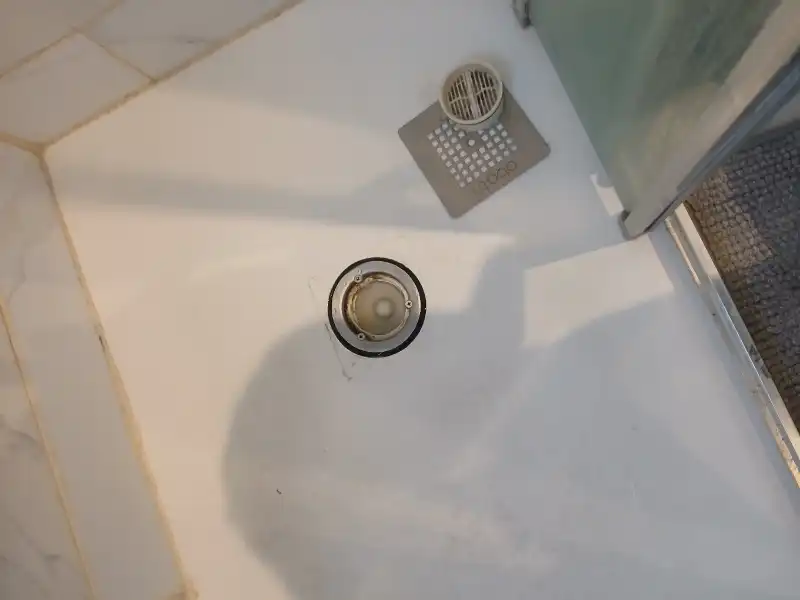 Fontanero Bilbao en Recalde realizando la limpieza y desatasco del desagüe de un plato de ducha.